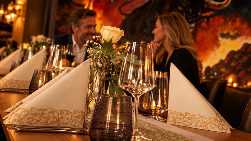 Weiße Rose, Gläser und goldverzierte Servietten